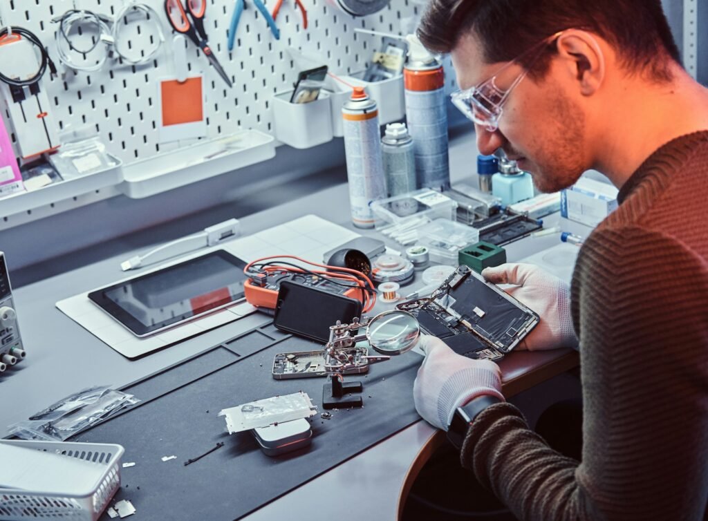 Technician carefully inspect the internal parts of the smartphone in a modern repair shop